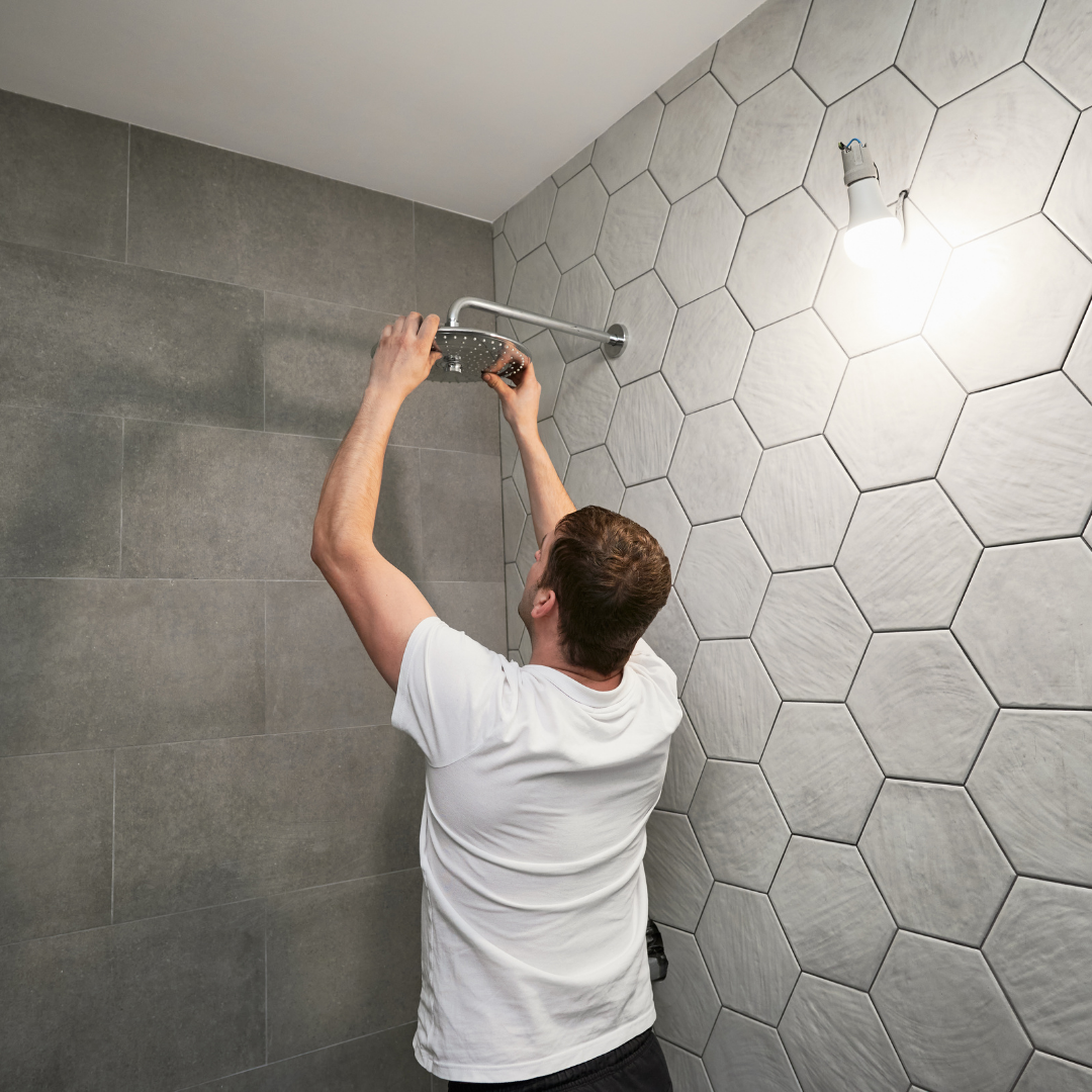 Loodgieter monteert een douche in een badkamer