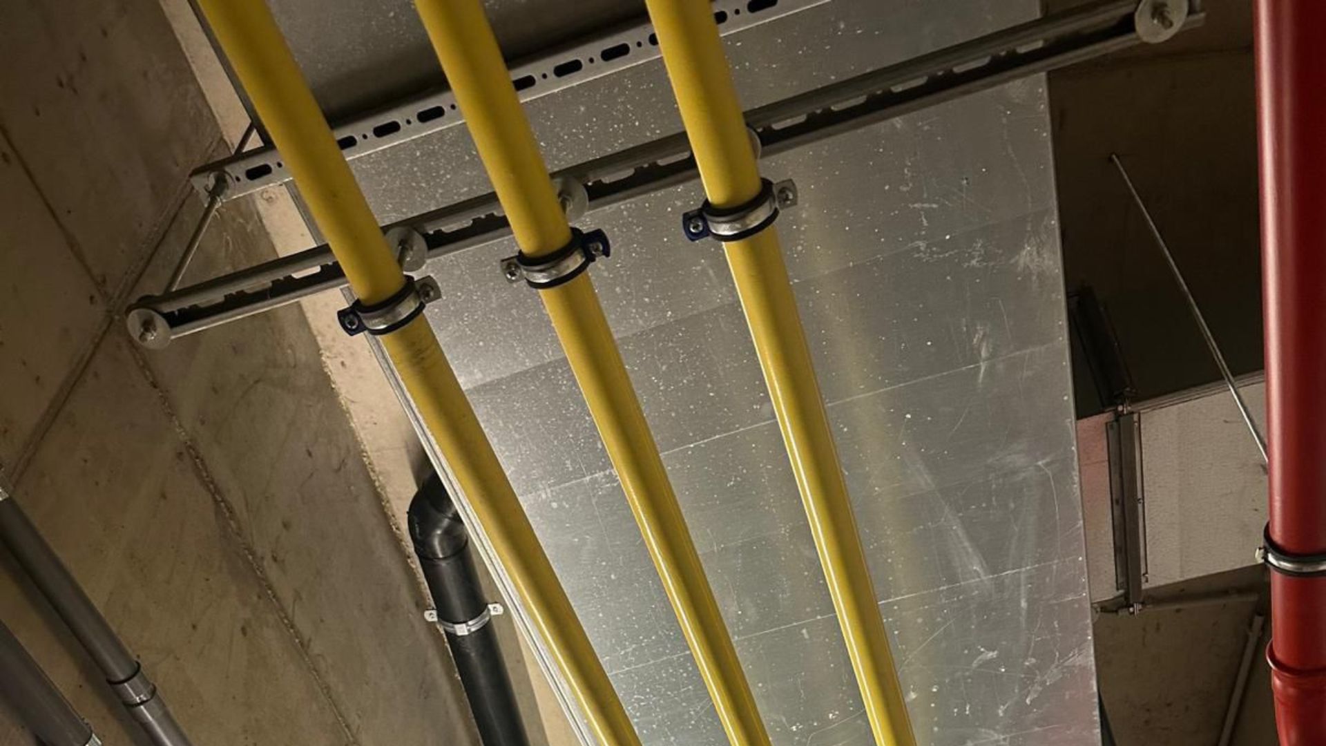 Gele gasleidingen en leidingwerk aan een plafond