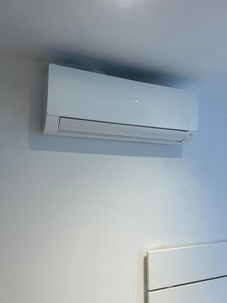 Witte airco-binnenunit hoog aan een binnenmuur